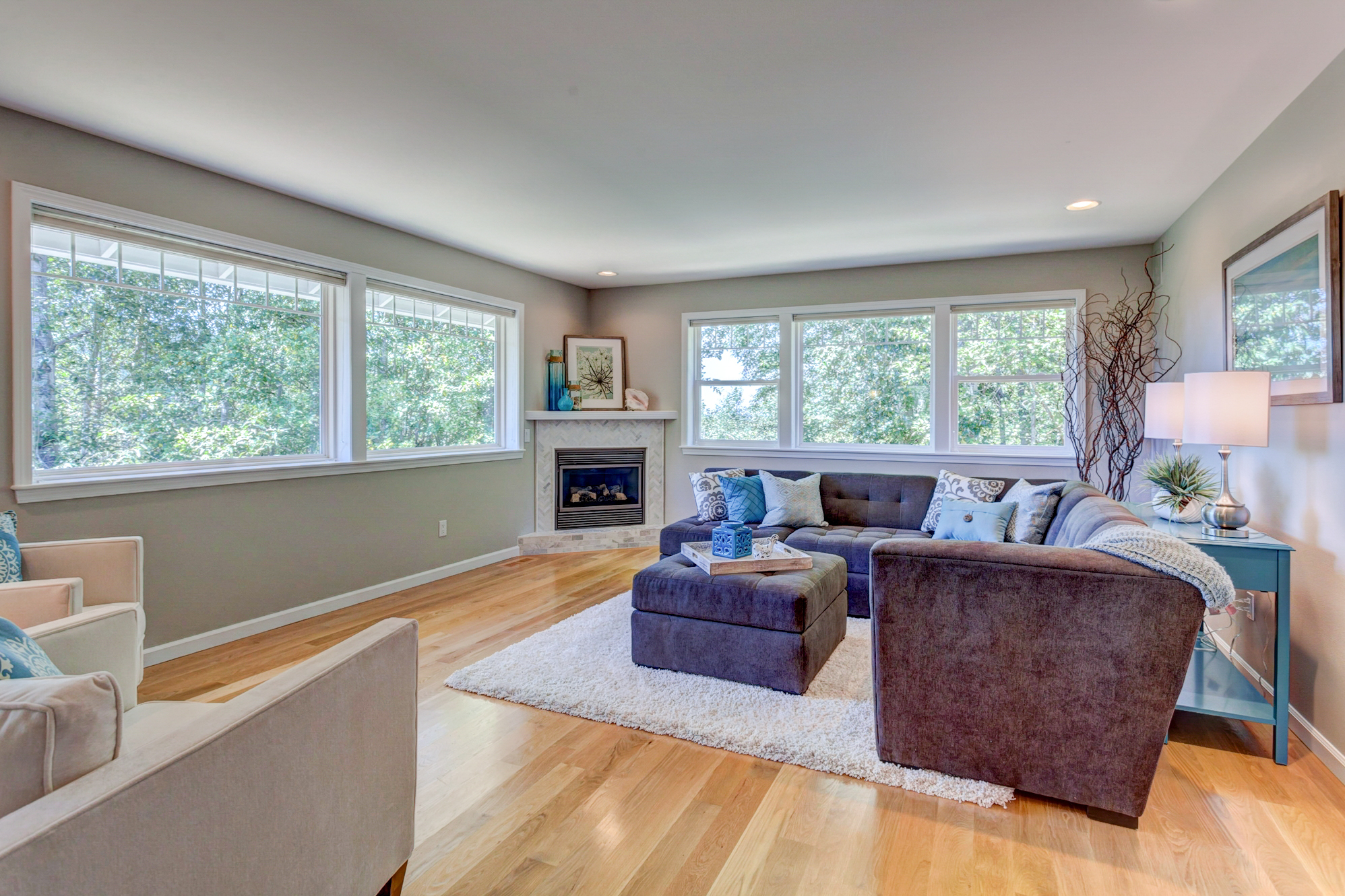 Property Photo: The living room is very spacious and sunny with the picture windows looking out to nature. the windows are west facing and allow the natural light to stream in. the gas fireplace insert is a lovely and adds a focal point to this large room. 3817 Fielding Ave  WA 98229 